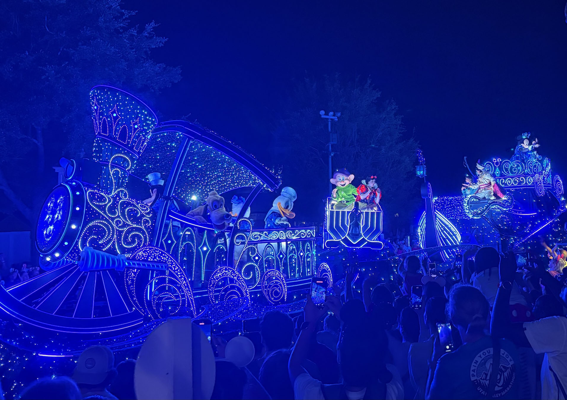 A nighttime light parade with glowing character floats